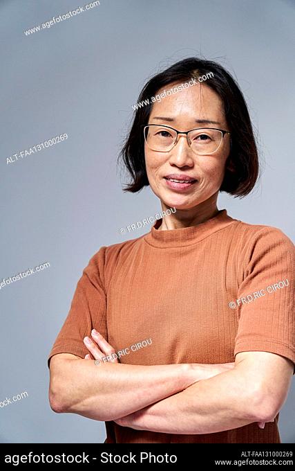 Mature Asian woman looking at the camera with arms crossed