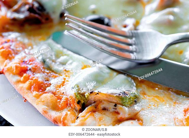 close-up picture of a crispy pizza-edge with fork