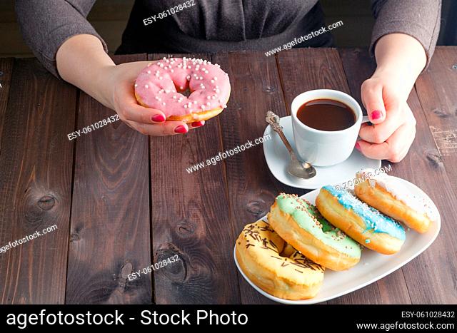 Woman eat donut and drink coffee, breakfast concept