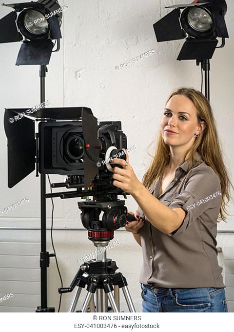 Photo of a woman operating a dslr camera rig for a video shoot