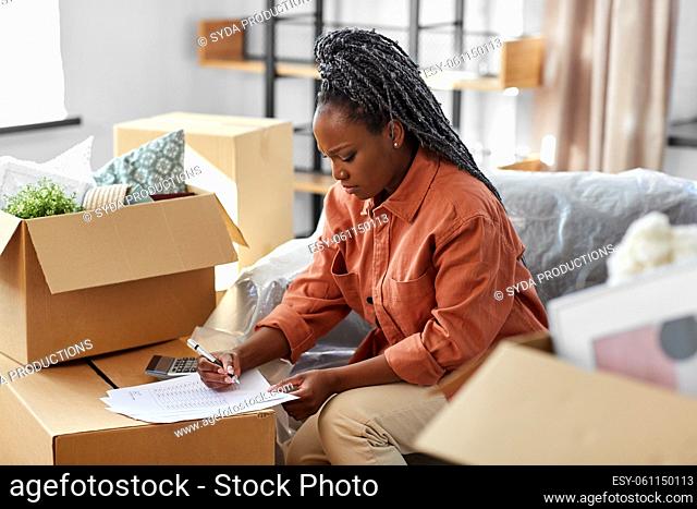 woman with bills and calculator moving to new home