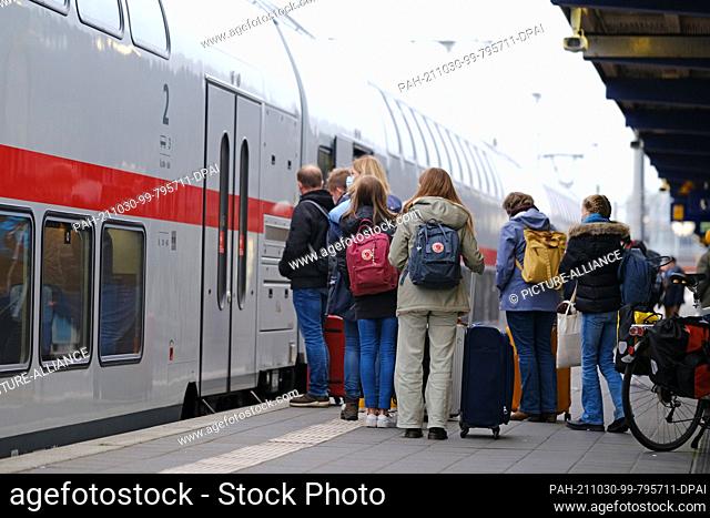 30 October 2021, Lower Saxony, Norddeich: People stand in front of a train on a platform at Norddeich Mole station on Saturday morning