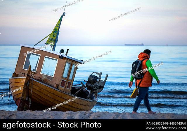 22 March 2021, Mecklenburg-Western Pomerania, Ahlbeck: A wooden fishing boat lies on the beach. Photo: Jens Büttner/dpa-Zentralbild/ZB