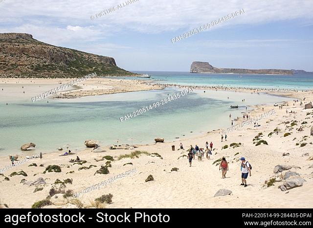 12 May 2022, Greece, Kissamos: Tourists walk on the beach of Balos in the northeastern part of the island of Crete. Photo: Socrates Baltagiannis/dpa