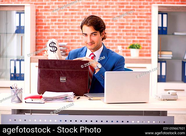 Young handsome employee working in the office