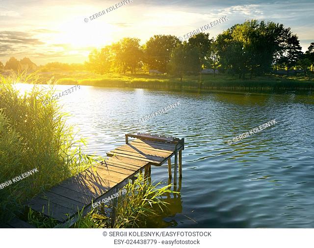 Wooden pier on a river in evening