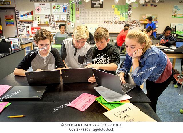 Caucasian middle school STEM (Science, Technology, Engineering and Math) students use Google Chromebook laptops in science class in Mission Viejo, CA