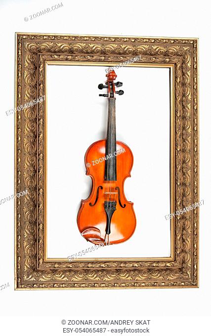 Violin and golden frame on an isolated studio backgound