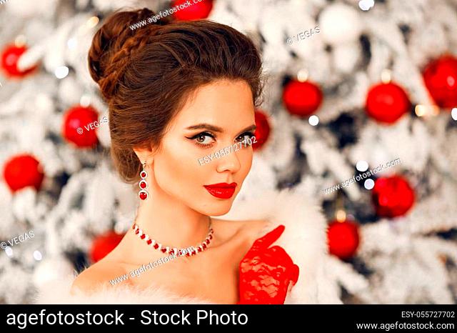 Bride portrait of Elegant woman with ruby jewelry set and red gloves. Beautiful brunette lady with wedding hairstyle, beauty makeup wears posing over xmas tree...