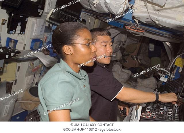 Astronauts Stephanie Wilson, STS-120 mission specialist; and Daniel Tani, Expedition 16 flight engineer, work the controls of the Space Station Remote...
