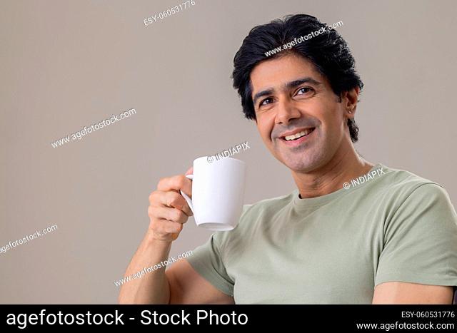 Indian middle age man having a cup of tea at morning