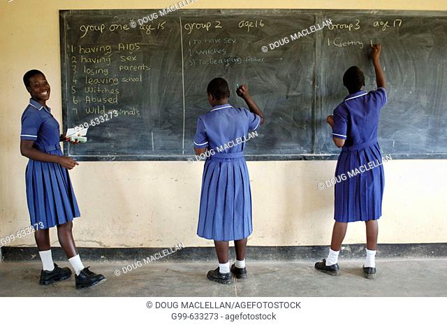 Three members of the Nyachuru High School AIDS Club write on the chalkboard a list of the their fears. The exercise is prompted by a Canadian guest lecturer