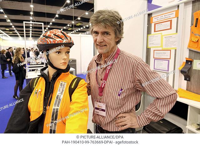 10 April 2019, Switzerland, Genf: Reinhold Kett from the district of Dachau near Munich presents his warning vest for cyclists at the Geneva Inventors' Fair