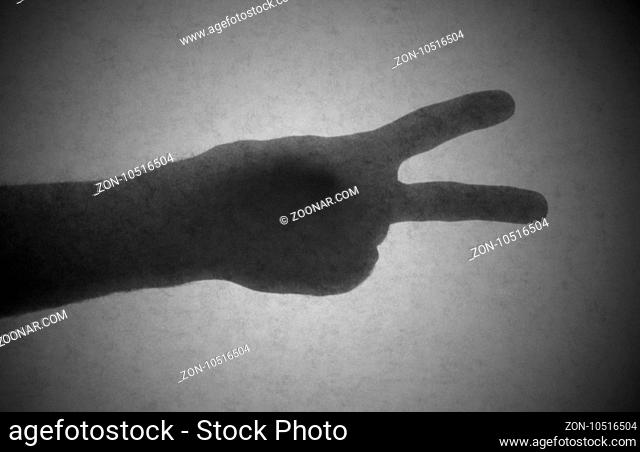 Silhouette behind a transparent paper - Peace or victory