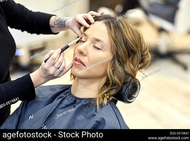 Make-up artist putting on a woman's face, hairdressing salon and beauty clinic