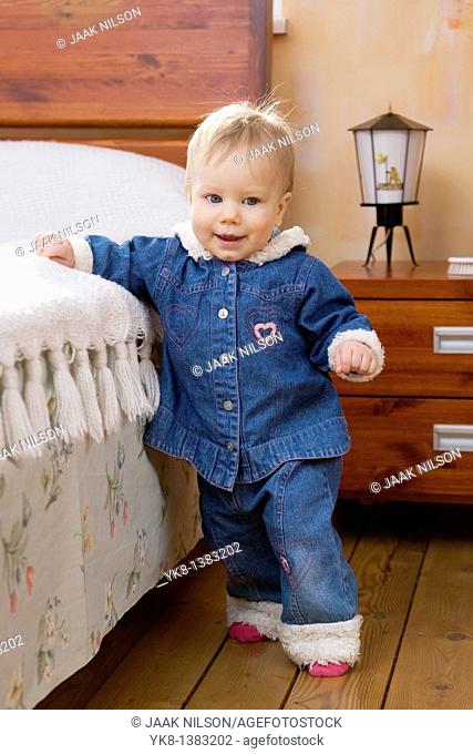Happy Smiling Ten Month Old Baby Walking First Steps by Bed
