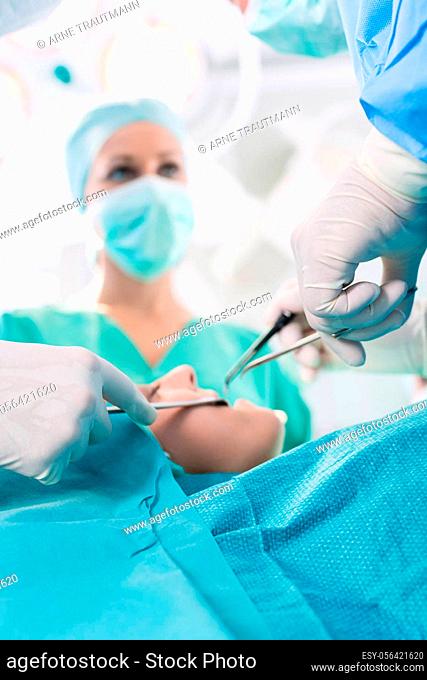 Surgeons operating patient in operation theater of hospital