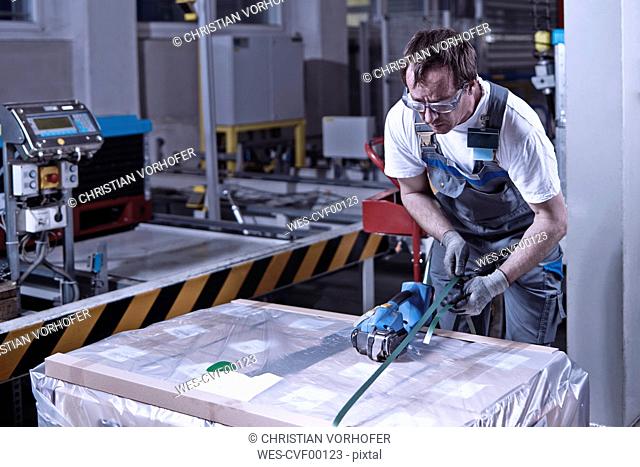 Worker closing freight with foil