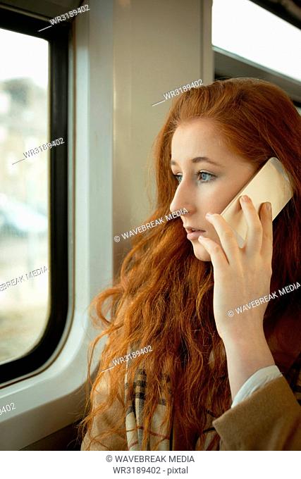 Woman talking on mobile phone while travelling in train