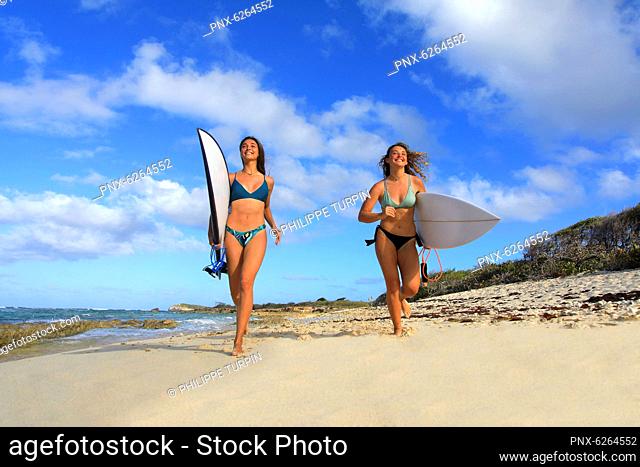 Two surfing girls on the beach