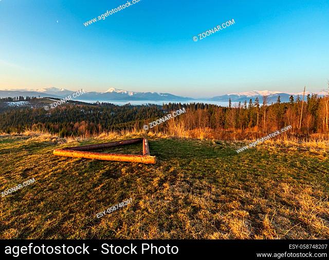 Early morning spring Carpathian mountains plateau landscape with snow-covered ridge tops in far, Ukraine