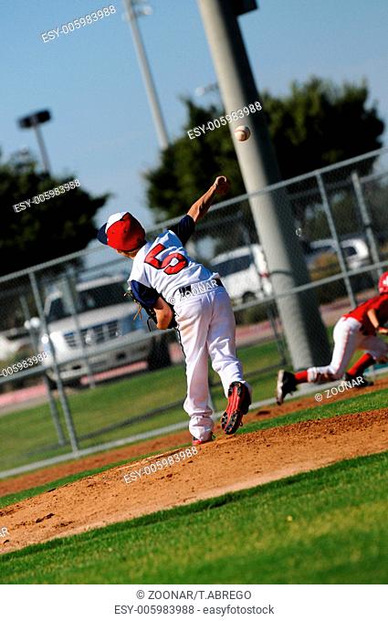 Little league pitcher throwing to first
