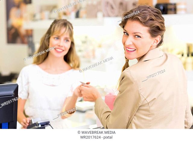 Beautiful customer at cash register giving credit card