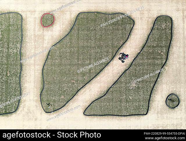 29 August 2022, Baden-Wuerttemberg, Neustetten: A boy rides a go-kart track at the edge of the Wolfenhaus corn maze. (Aerial view with drone)