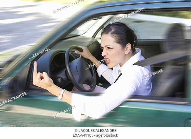 Young woman gesturing through car window