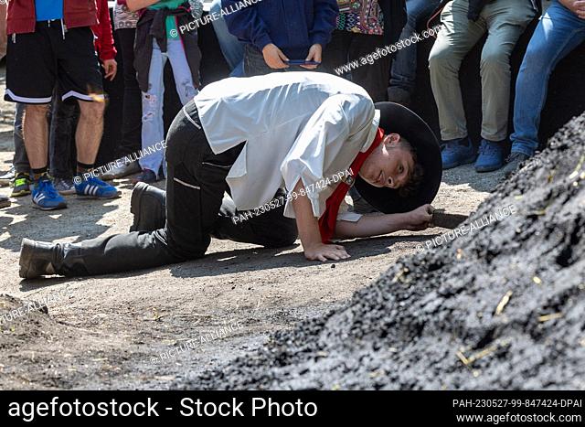 27 May 2023, Saxony, Tharandt: 16-year-old Niklas Papperitz lights another charcoal pile in the Breiten Grund in the Tharandt Forest