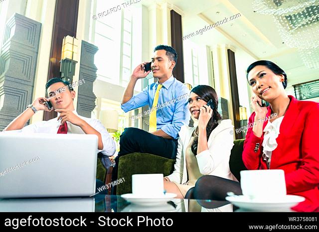 Asian Businesspeople talking on cell phone