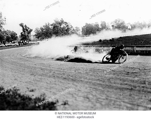 Dirt track motorbike racing, 1913. A motorcycle speeds around a bend on a dirt track, throwing up a cloud of dust behind it