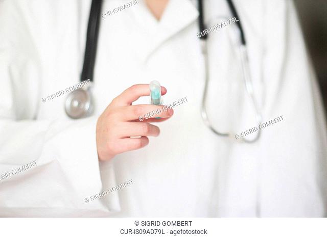 Close up studio shot of female doctor holding syringe