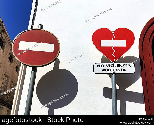 Zwei Verkehrsschilder werfen Schatten, Einfahrt verboten, gebrochenes Herz, Aufschrift No Violencia Machista in einer Kampagne gegen häusliche Gewalt