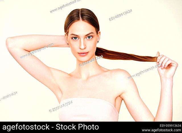 Close up portrait of beautiful young woman with natural make up posing on studio background. Female beauty, spa, clean skin concept