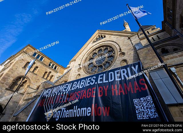 07 December 2023, North Rhine-Westphalia, Cologne: A banner with the inscription ""Men. Women. Babies. Elderly. are still held hostage by Hamas"" stands in...
