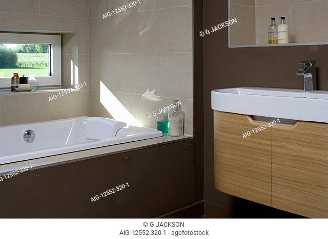 Dark brown bathroom with recessed bathtub in carbon neutral home in Crossway, Kent, England
