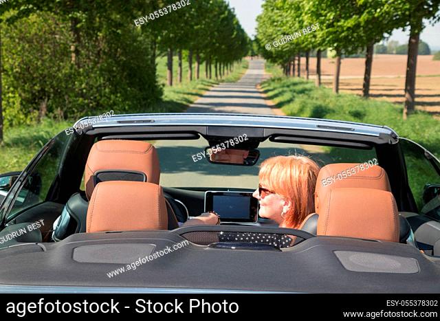 Senior couple in convertible car enjoying day trip
