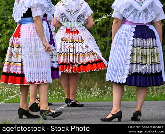 12 August 2023, Brandenburg, Heinersbrück: Young women in Sorbian-Wendish festive costumes wait for the beginning of the village and harvest festival