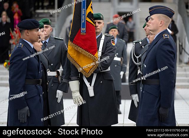 12 November 2023, Berlin: Recruits stand for the oath around a German flag at the ceremonial pledge to mark the 68th anniversary of the founding of the...