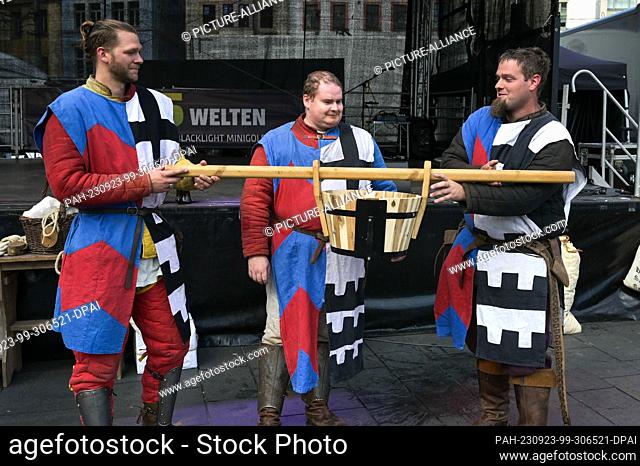 23 September 2023, Saxony-Anhalt, Halle (Saale): The performers of the Thuringian Order of Knights with a water trough for the Bornknechtrennen