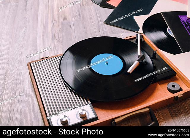 Vintage Gramophone with a vinyl record on gray wooden table, top view and copy space