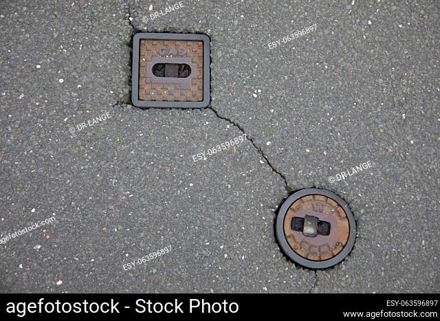 Manhole cover and hydrant embedded in the road surface