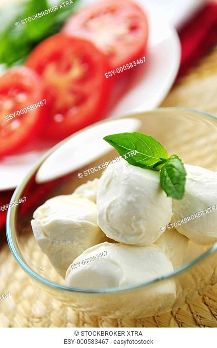 Bocconcini cheese, basil and sliced tomatoes - ingredients of traditional Italian cuisine