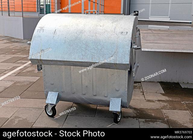 Silver Industrial Dumpster Container in Front of Warehouse