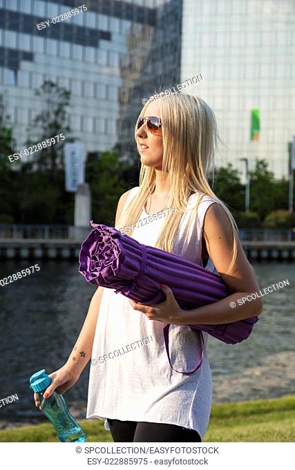 Woman in sportswear with camping mat looking for a place