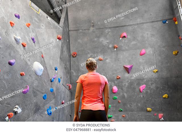 young woman at indoor climbing wall in gym