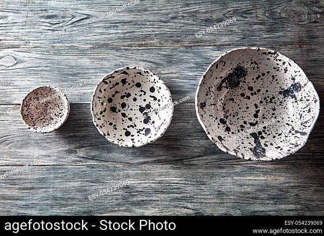 Traditional souvenir ceramic handcrafted plates and bowls on a concrete background with place under text. Flat lay