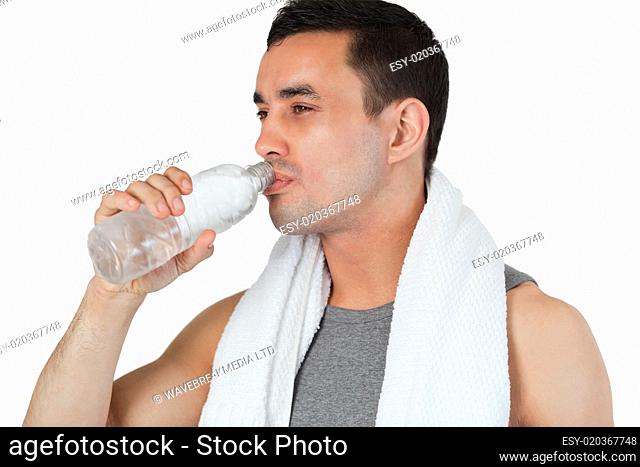 Young man taking a sip of water after workout