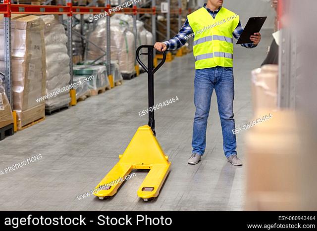 man with loader and clipboard at warehouse